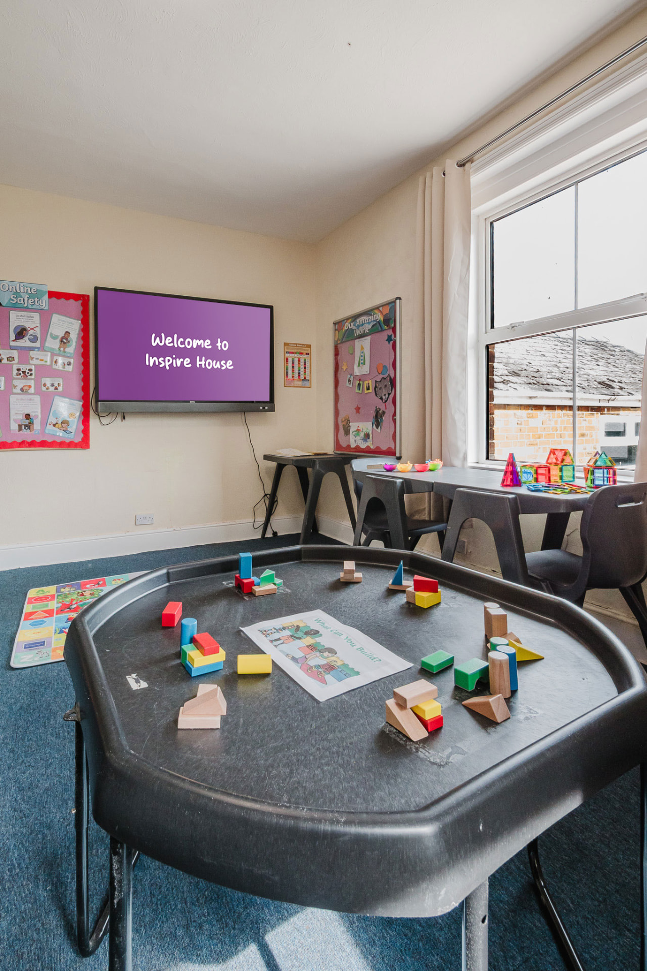 Tuff tray with building blocks and a Welcome to Inspire House screen