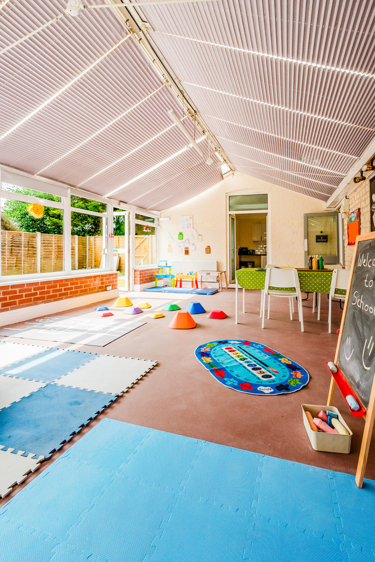 Sunlit classroom with soft play mats and activity area