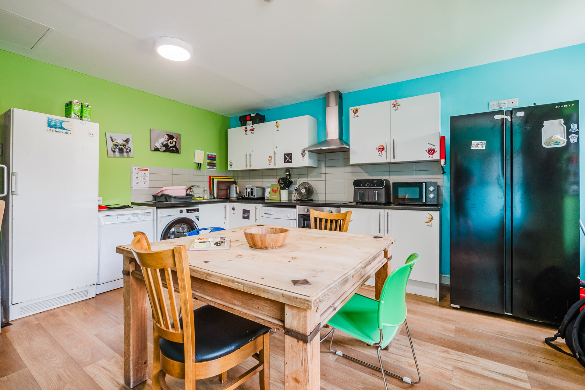Colourful kitchen with green and teal walls and family dining table