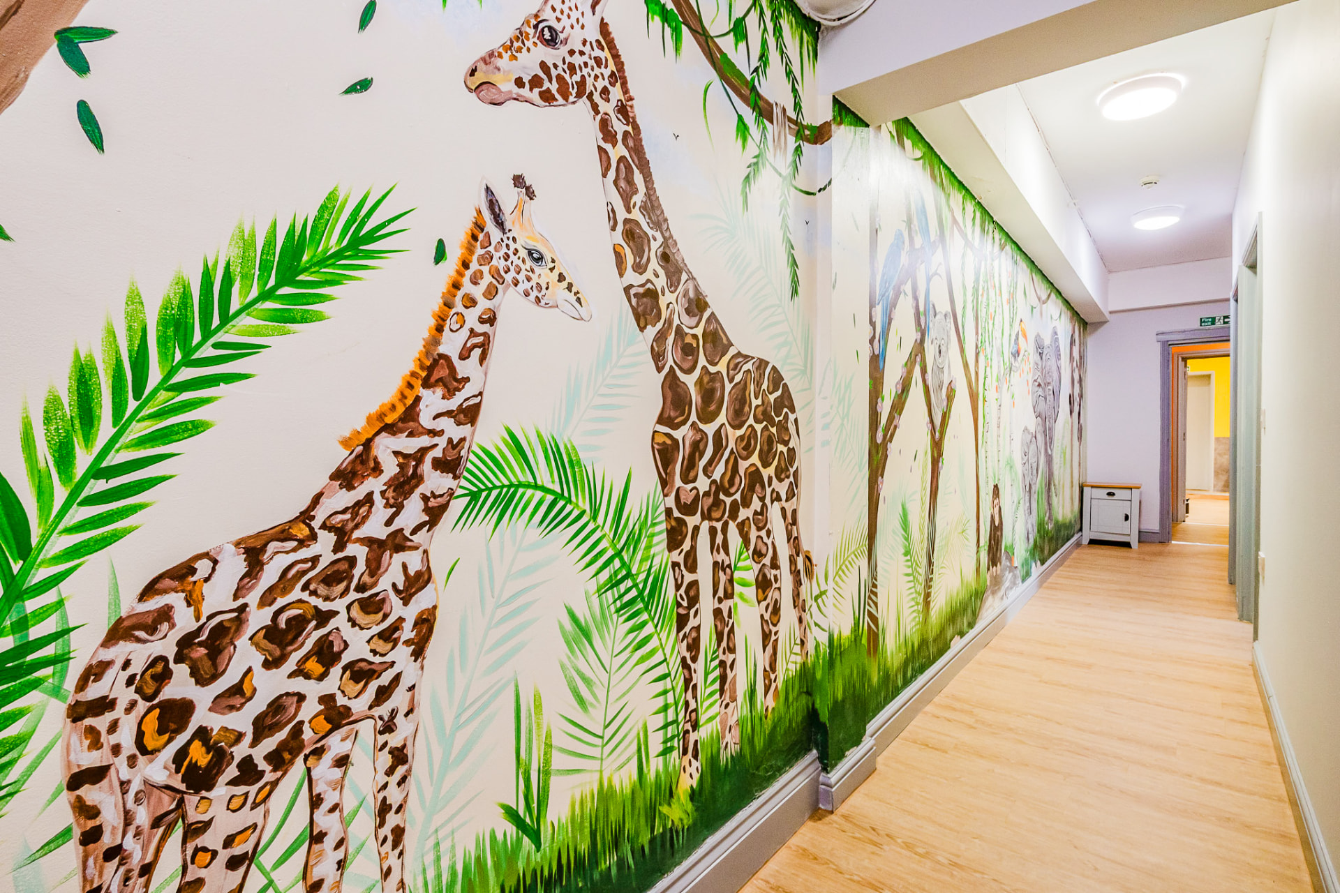 Giraffe jungle mural along the hallway