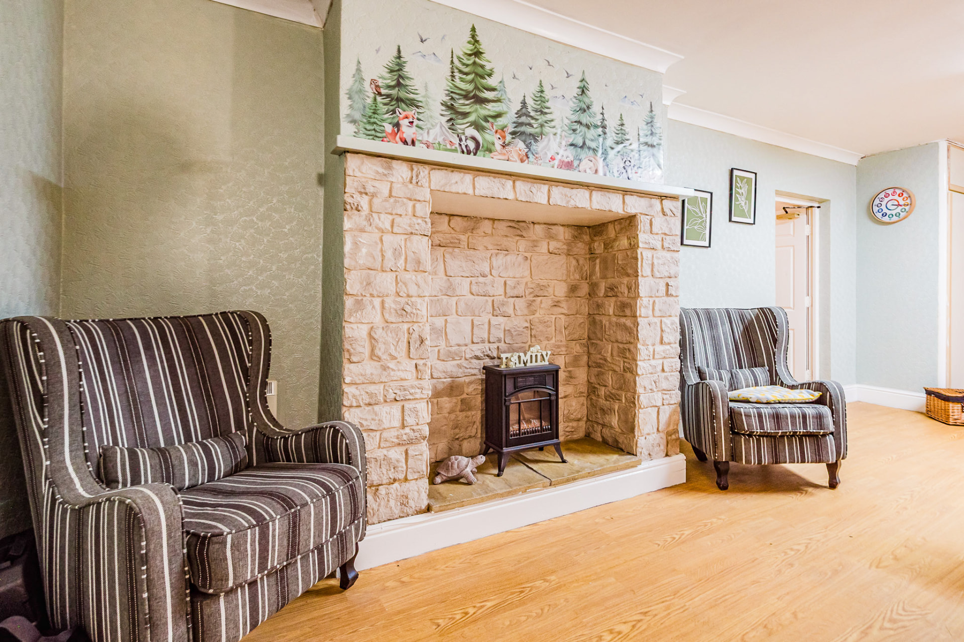 Lounge with stone fireplace and woodland mural