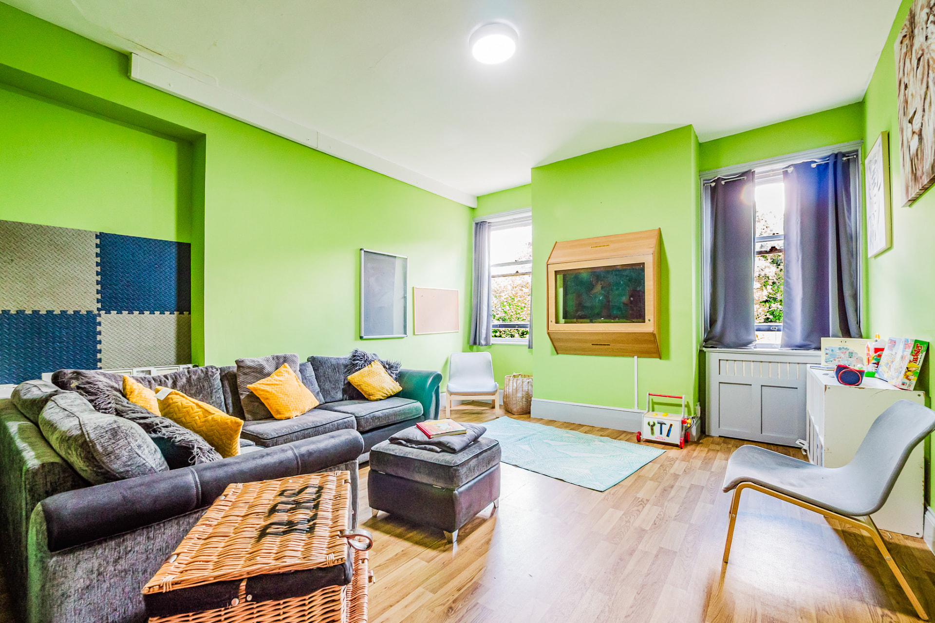 Green lounge with corner sofa and fish tank