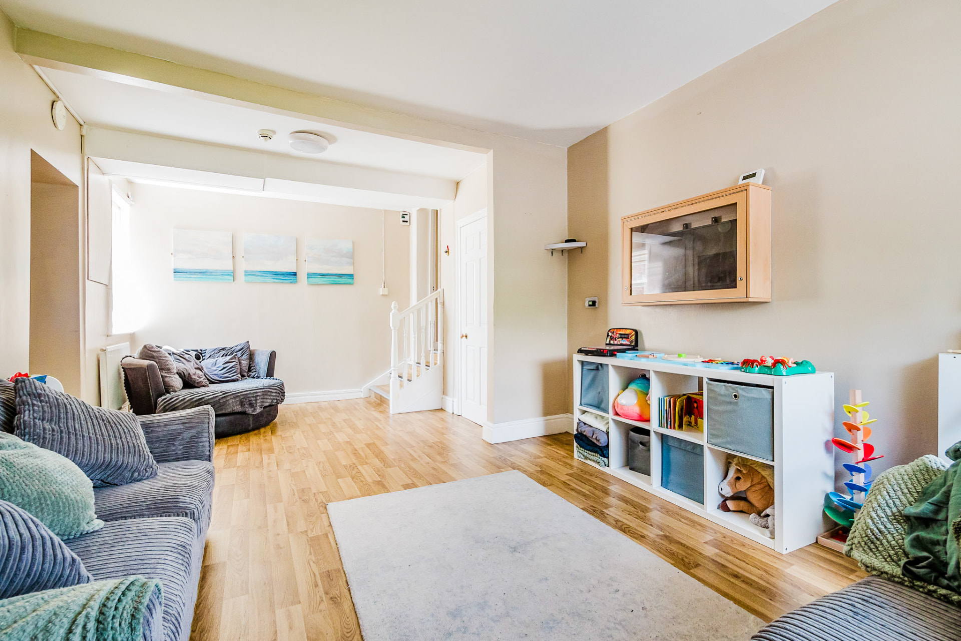 Open-plan living room with soft seating and toy storage
