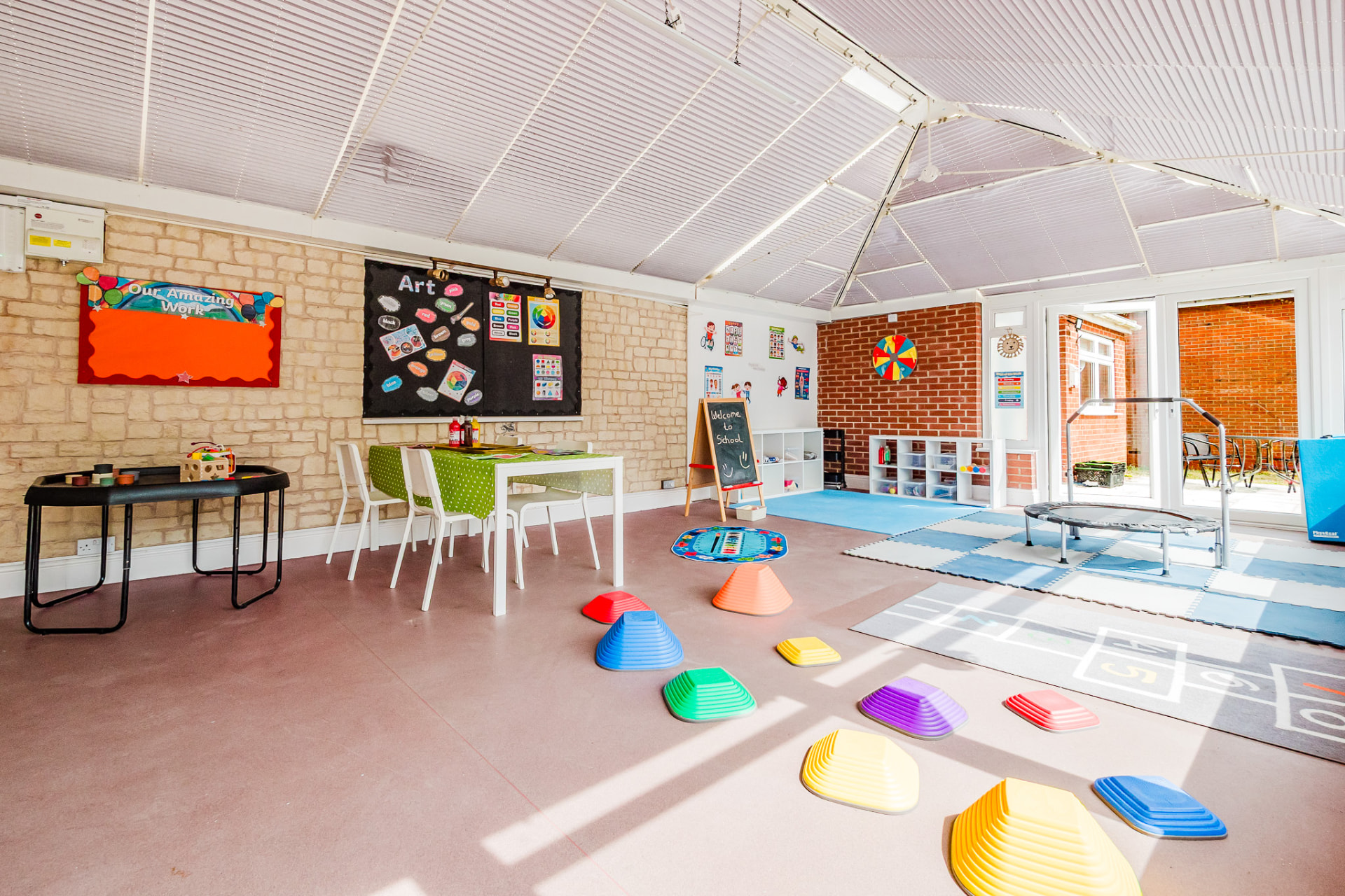 Bright classroom with art displays and physical play equipment