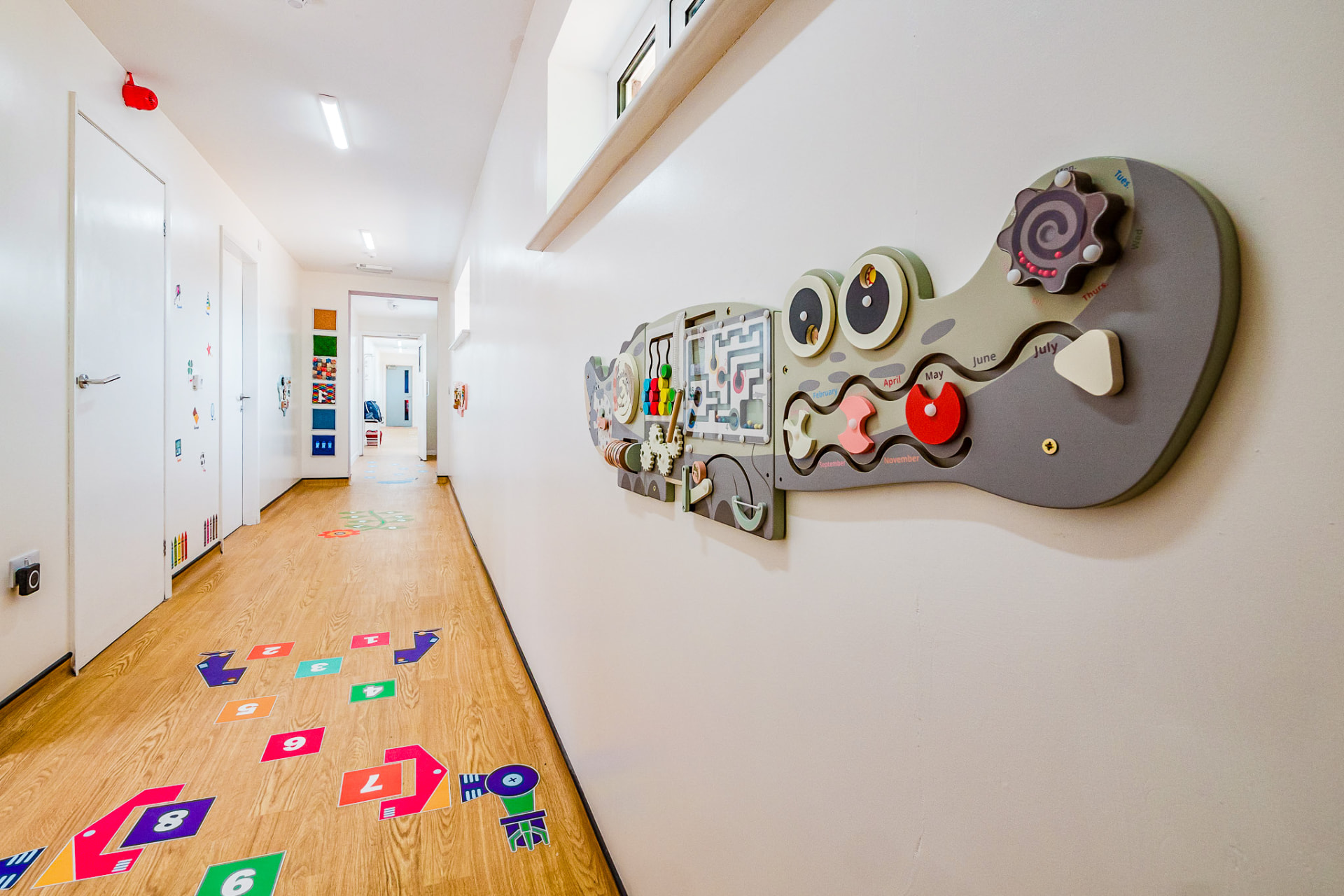 Corridor with sensory wall panels and hopscotch floor markings
