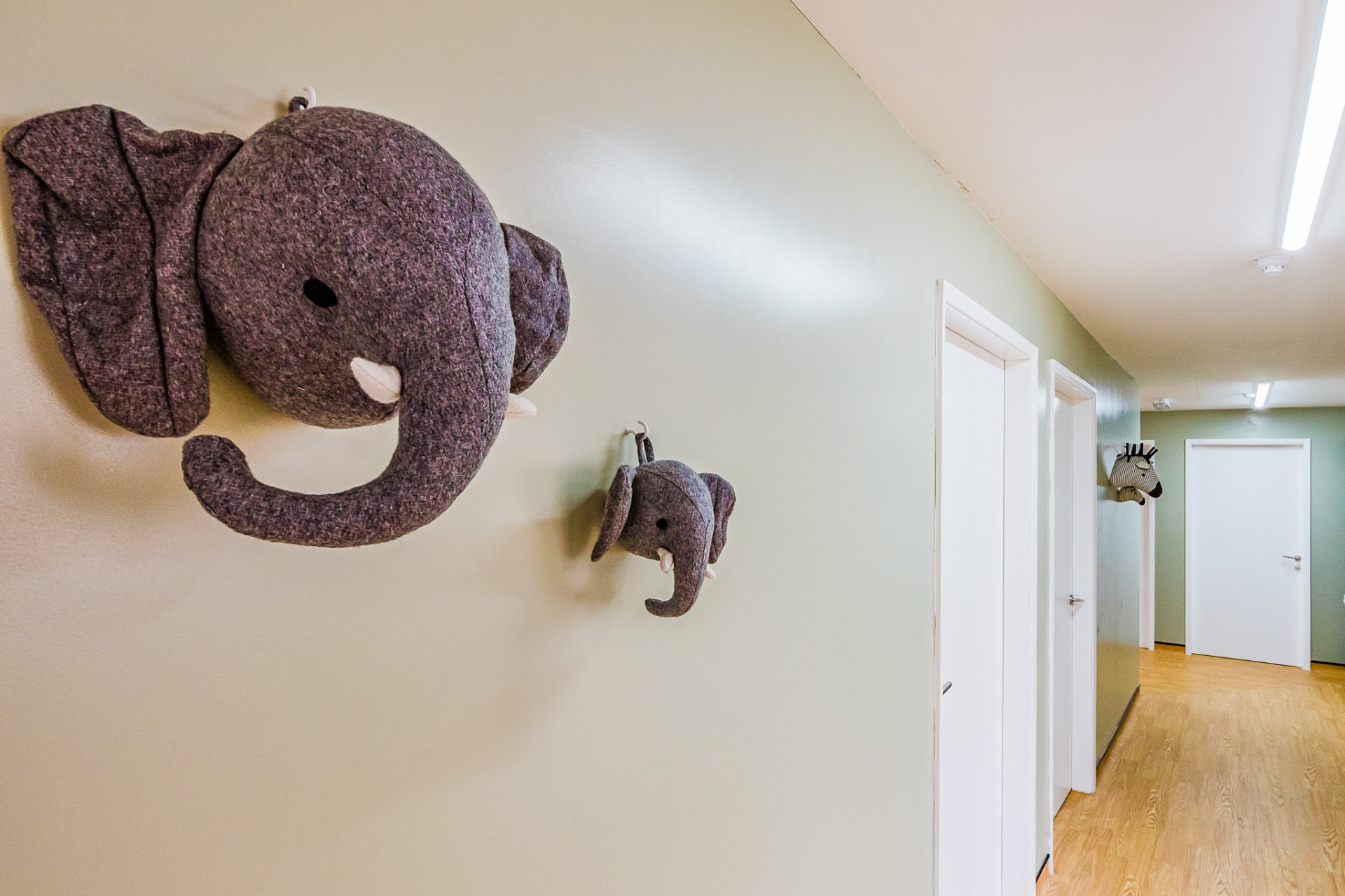 Soft felt elephant wall decorations along a hallway